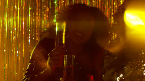 Close-Up-Of-Two-Women-Dancing-In-Nightclub-Bar-Or-Disco-Drinking-Alcohol-With-Sparkling-Lights-14